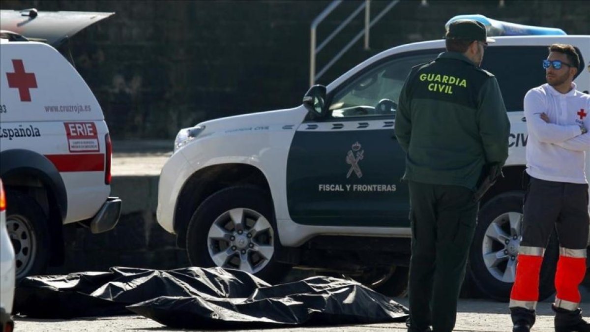 Agentes de la Guardia Civil y miembros de la Cruz Roja, junto a uno de los cadáveres de inmigrantes hallados en aguas del Estrecho.