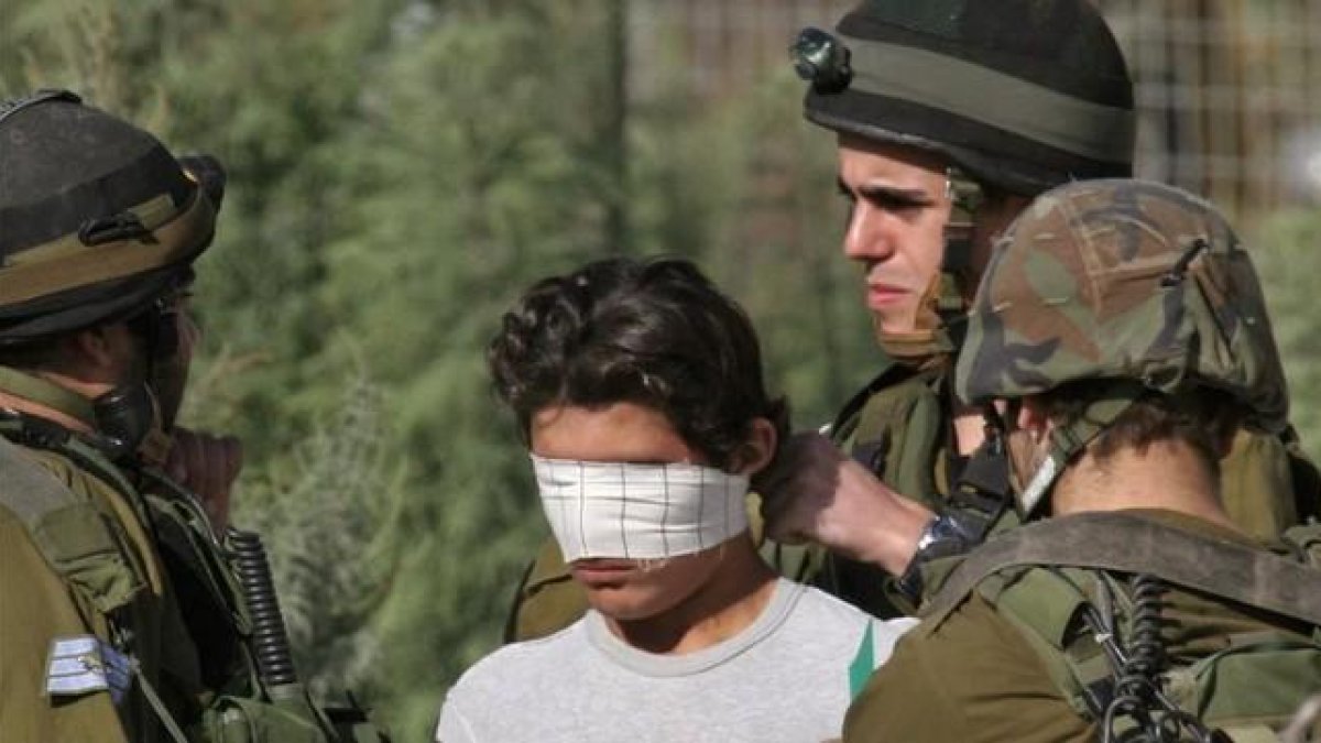 Un soldado israelí venda los ojos de un detenido palestino cerca de Nablus, en Cisjordania.