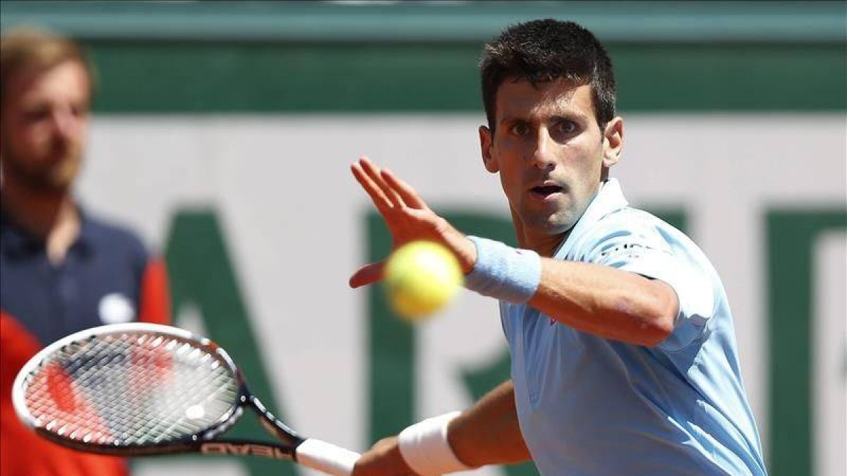 El tenista serbio Novak Djokovic golpea la bola durante la semifinal del Roland Garros que disputó hoy contra el letón Ernests Gulbis, en París.