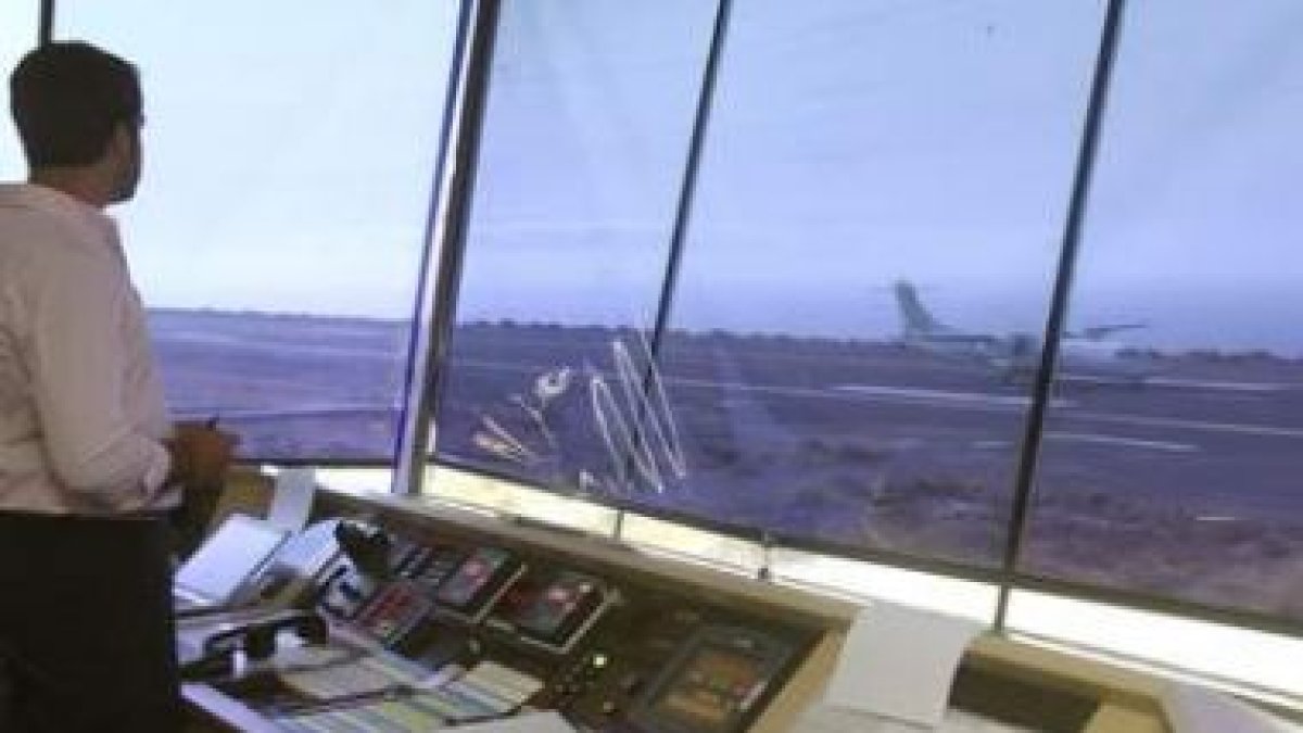 Un operario observa desde la torre de control el aterrizaje de un avión.