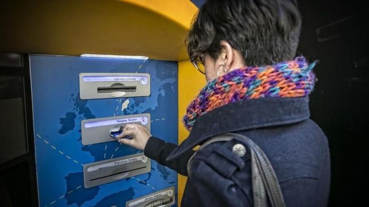 Una mujer saca dinero en un cajero automático.