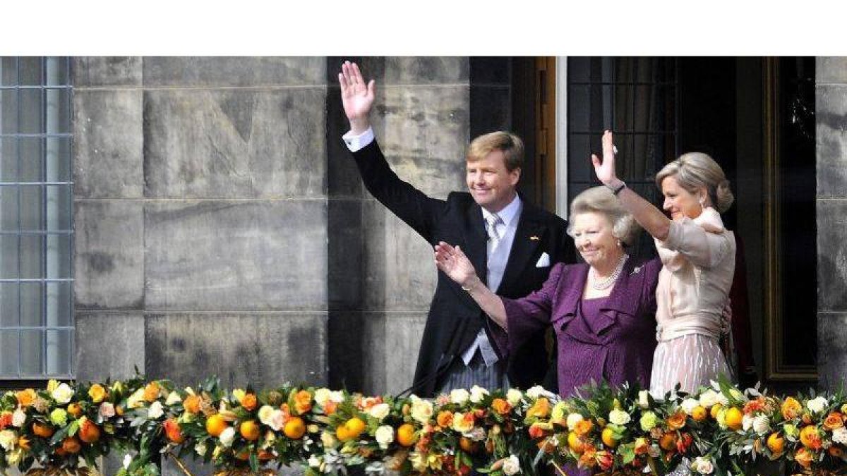 El nuevo rey, Guillermo-Alejandro (c), la princesa de los Países Bajos Beatriz de Orange (2ª dcha), y la reina consorte Máxima (dcha), saludan a los ciudadanos desde el balcón del Palacio Real en la Plaza Dam de Ámsterdam.