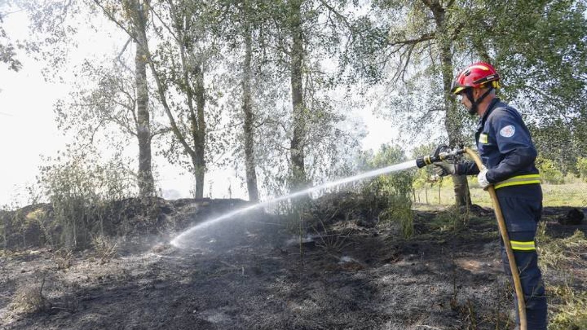 Un bombero refresca la zona después de un incendio. DL (ARCHIVO)
