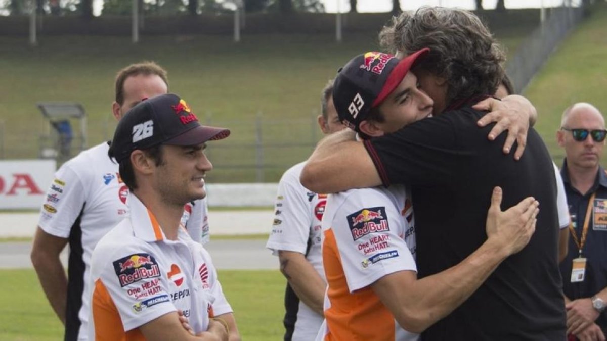 Paolo Simoncelli recibe el abrazo de Marc Márquez, ante la presencia de Dani Pedrosa, en el reciente homenaje que MotoGP dedicó, en Sepang (Malasia), a su hijo Marco.