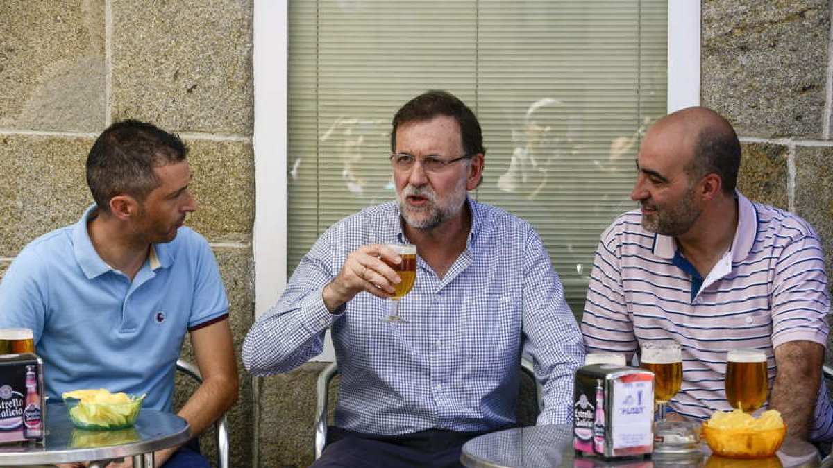 Rajoy, en el centro, toma una caña con el alcalde de Celanova, a la derecha, un bar.