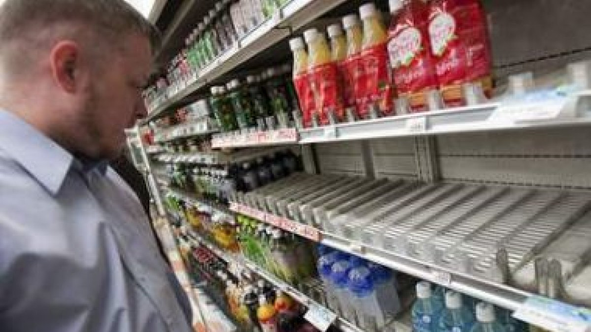 Un empresario extranjero busca agua embotellada en un supermercado de Tokio.