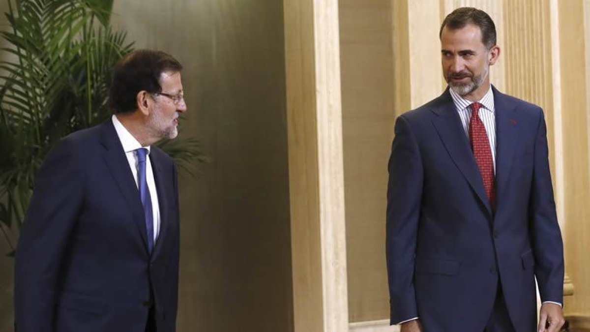 El Rey Felipe VI conversa con el presidente del Gobierno, Mariano Rajoy, antes de presidir hoy en el Palacio de la Zarzuela la reunión anual del patronato de la Fundación Carolina.