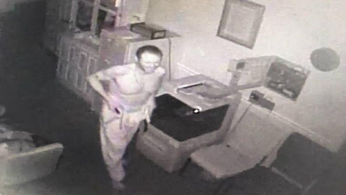 Una de las imágenes captadas por las cámaras de seguridad en la que se ve al ladrón vestirse con la ropa de uno de los difuntos.