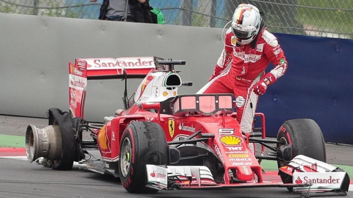Sebastian Vettel se baja de su Ferrari tras estallar una de sus ruedas.
