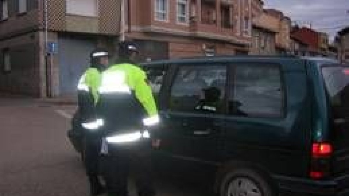 Dos agentes informan al conductor de un vehículo de los objetivos de la campaña