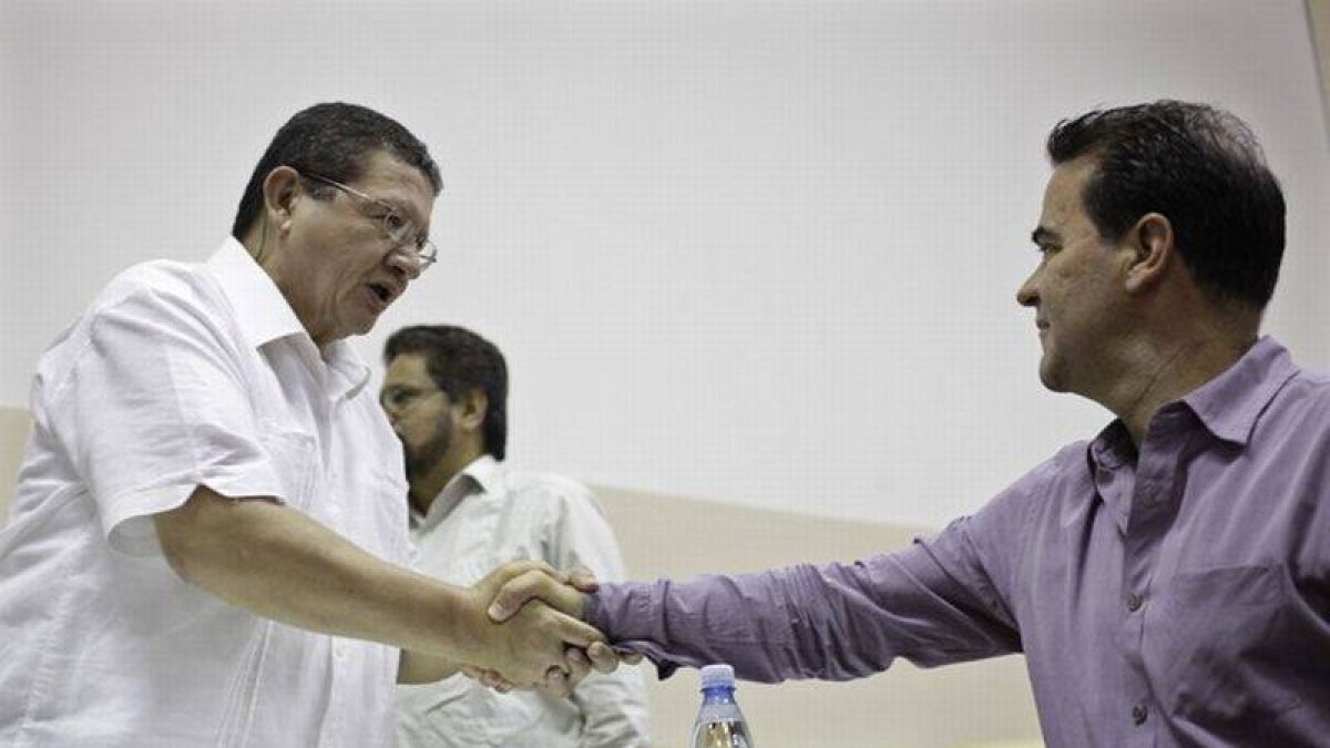 El negociador de las FARC Pablo Catatumbo (izquierda) saluda al representante del Gobierno de Colombia Frank Pearl, el domingo.