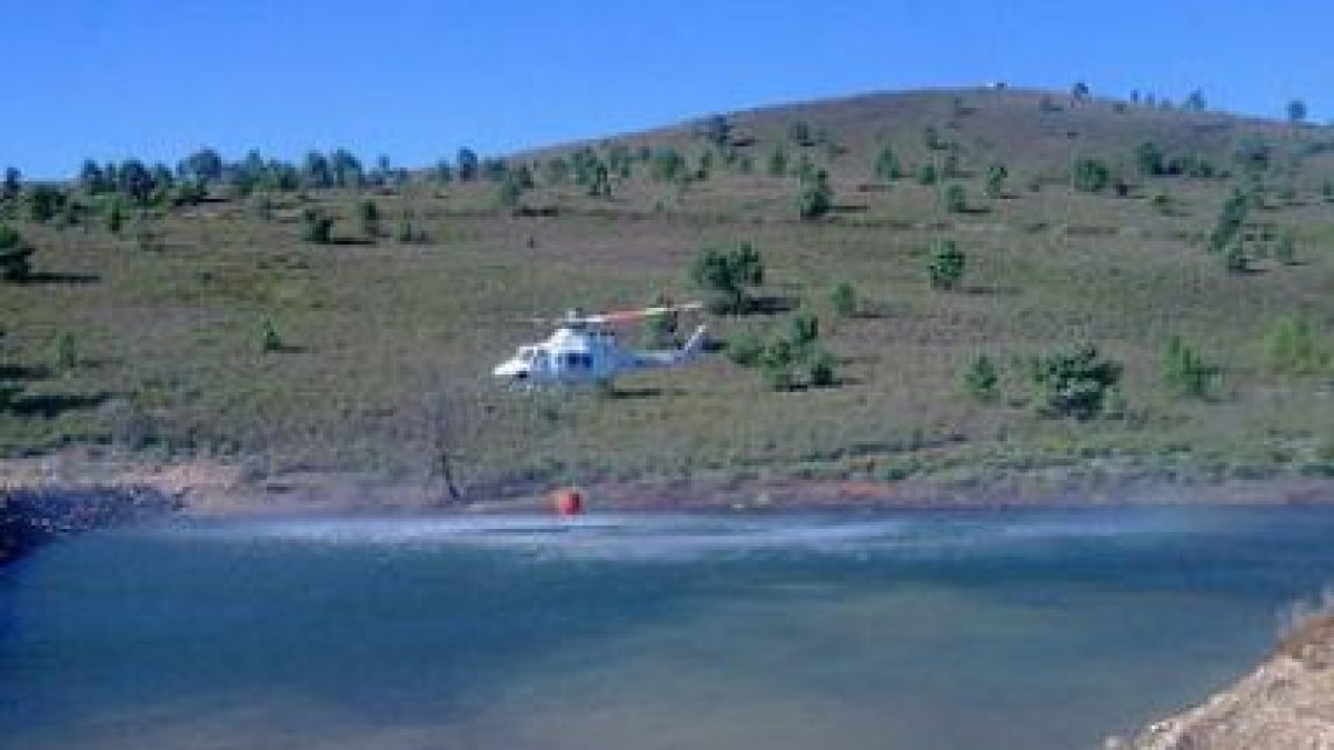 Un helicóptero aprovecha la balsa de San Feliz de la Lavanderas para cargar agua.