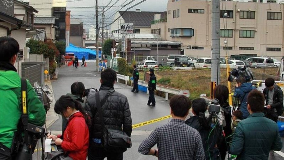 Periodistas japoneses montan guardia cerca del lugar (al fondo) donde ha aparecido el cadáver, este jueves en Kioto.