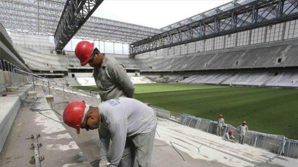 Trabajadores en las obras del estadio de Curitiba, este lunes.