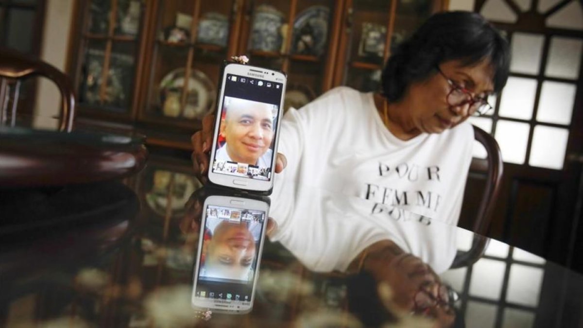 La hermana del piloto del avión de Malaysia desaparecido muestra una fotografía de su hermano.