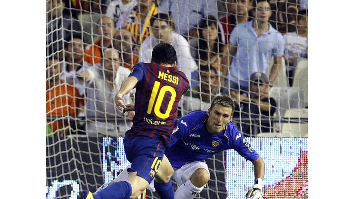 Leo Messi intenta regatear al portero del Valencia Vicente Guaita, que consigue frenar al argentino.