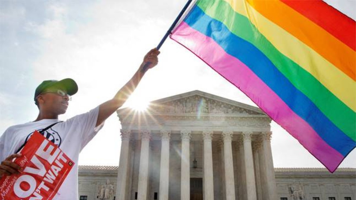 Un ciudadano estadounidense ondea una bandera del orgullo gay, ante en Tribunal Supremo.