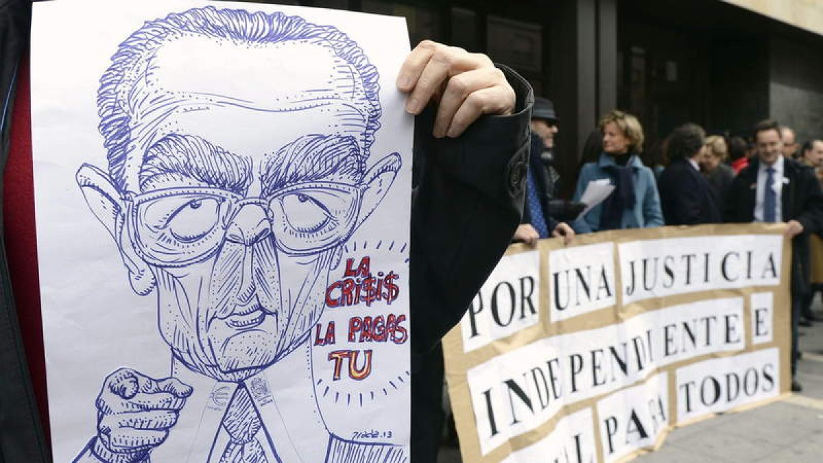 Un hombre sujeta una caricatura del ministro Gallardón durante una protesta de jueces.