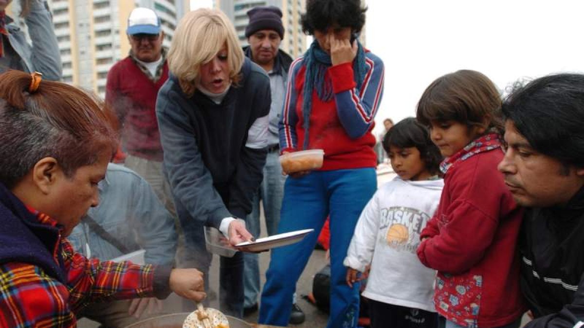 Una mujer sirve comida a unos niños en la ciudad de Buenos Aires, Argentina.