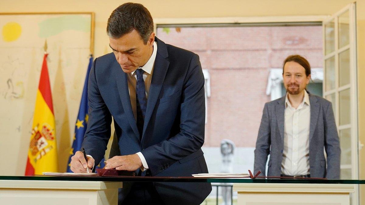 Pedro Sánchez firma el acuerdo presupuestario ante la mirada de Pablo Iglesias, en la Moncloa