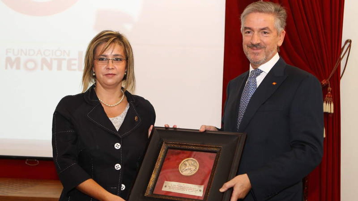 Martínez-Burgos recoge el galardón de manos de la decana de Economía, Nuria González.