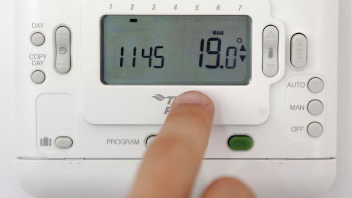 Un hombre manipula el termostato de su calefacción