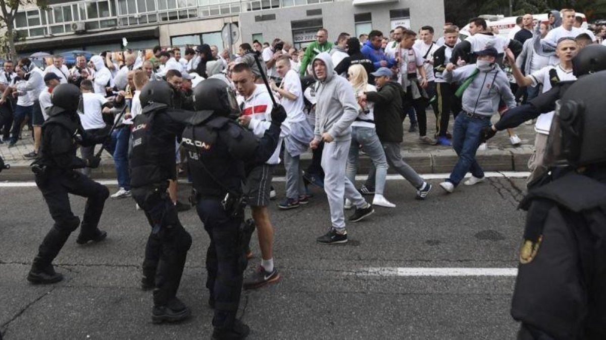 Aficionados del Legia se enfrentan a agentes de la Policia Nacional antes del comienzo del partido del martes contra el Madrid.