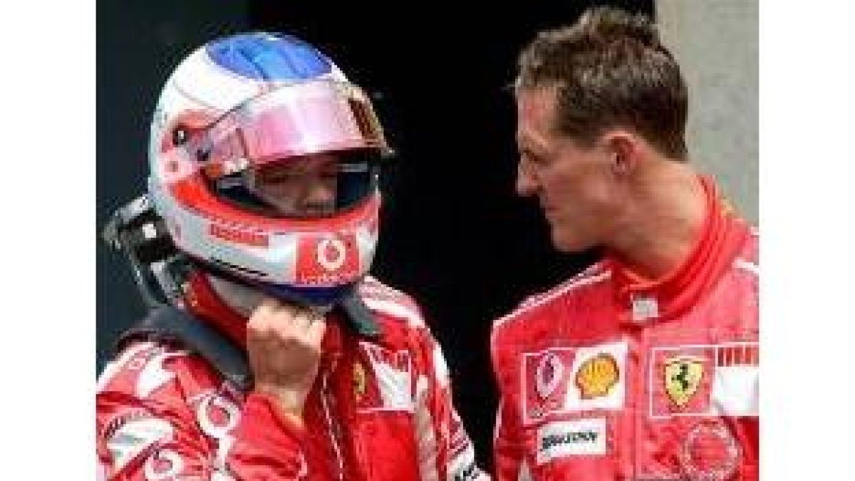 El alemán Michael Schumacher comenta las incidencias de la carrera con el piloto Barrichelo
