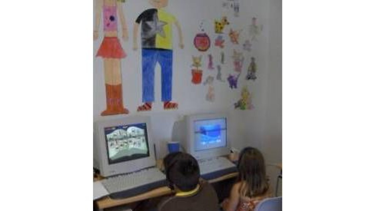 Niños jugando con el ordenador en el aula lúdica
