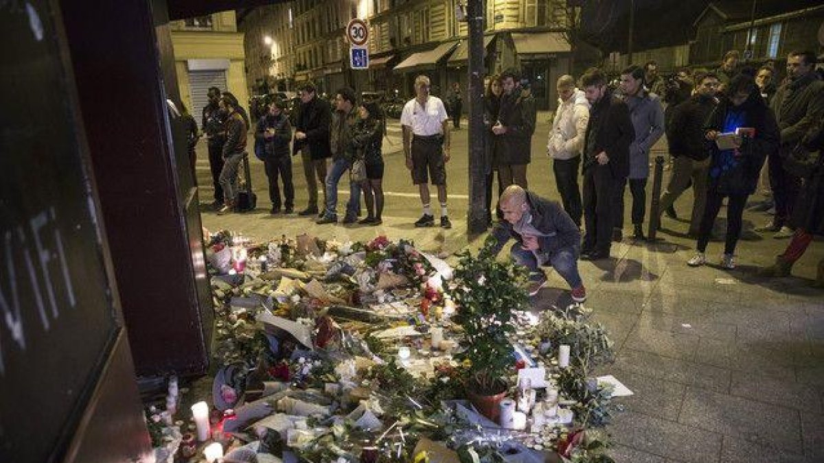 Los parisinos dejan flores y velas en honor a las víctimas de los atentados, en el café Carillon, en París.