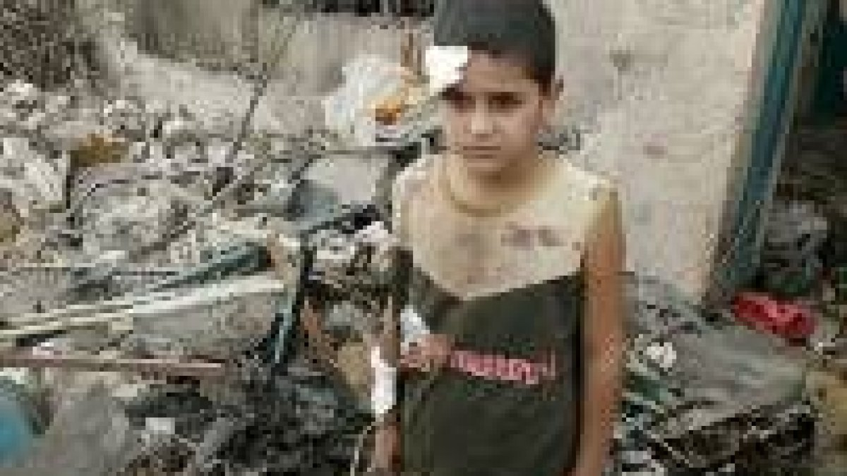 Un niño iraquí herido en la zona destruída por el coche bomba