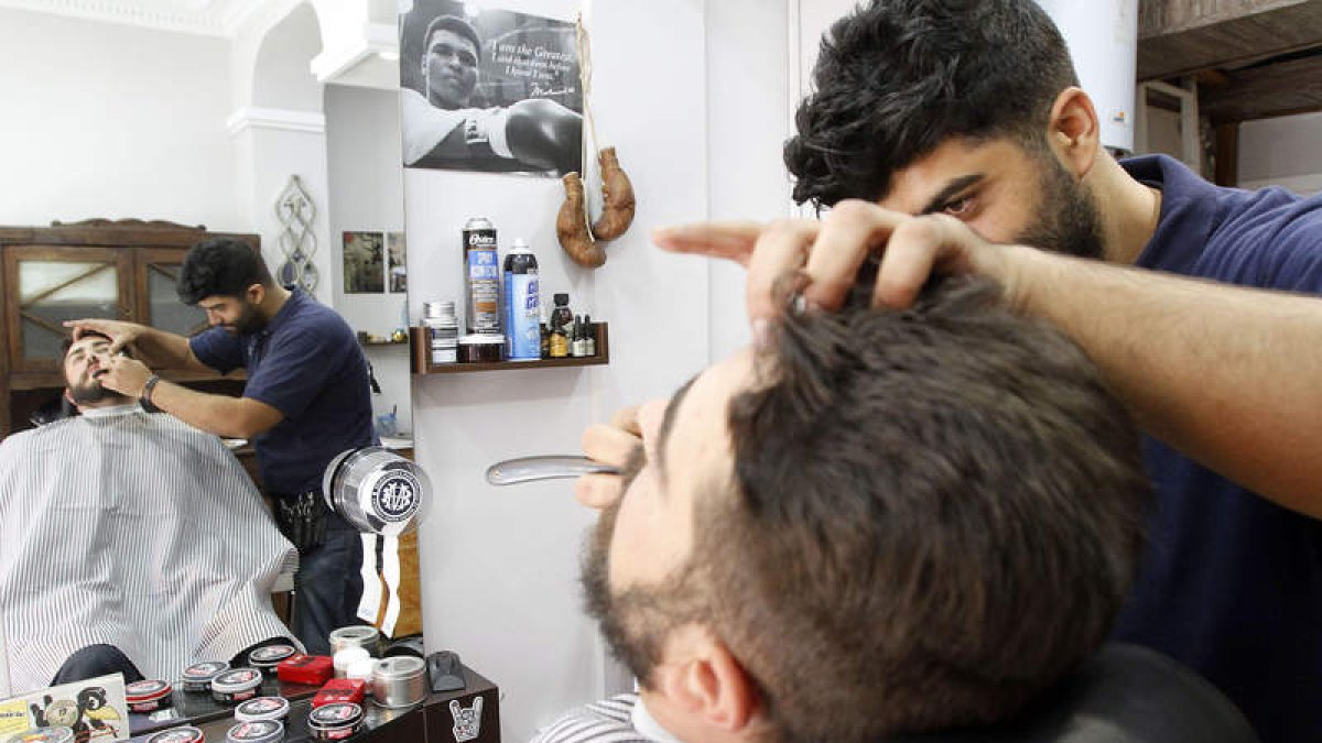 David arregla la barba a un cliente en su local de la calle Conde Guillén de la capital.