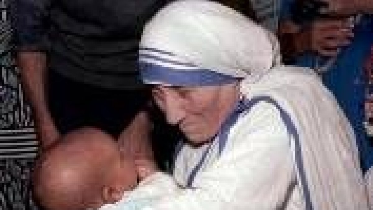 La madre Teresa de Calcuta sostiene un bebé en brazos en Sudáfrica