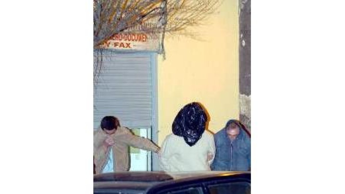 Uno de los detenidos sale con dos agentes del locutorio de Zougam