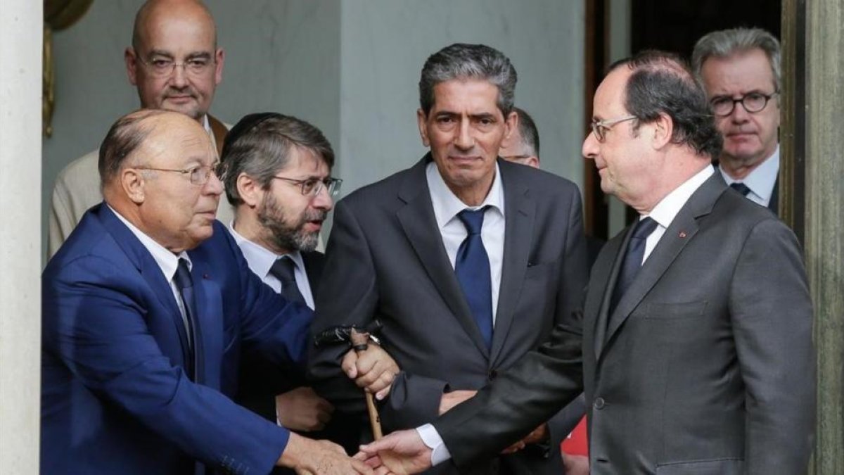Hollande estrecha la mano del rector de la Gran Mezquita de París, Dalil Boubakeur (izquierda), tras el encuentro en el Elíseo.