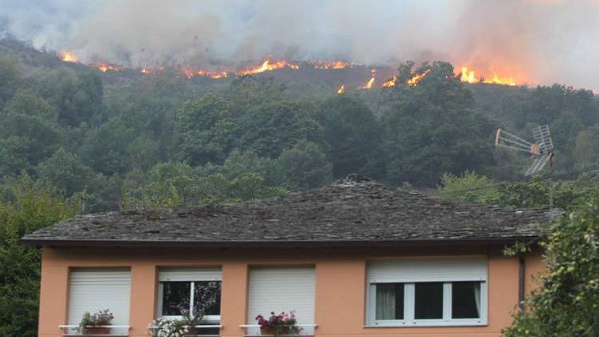 Las llamas, el pasado sábado, en su aproximación por el monte sobre algunas viviendas de Pereda de Ancares.