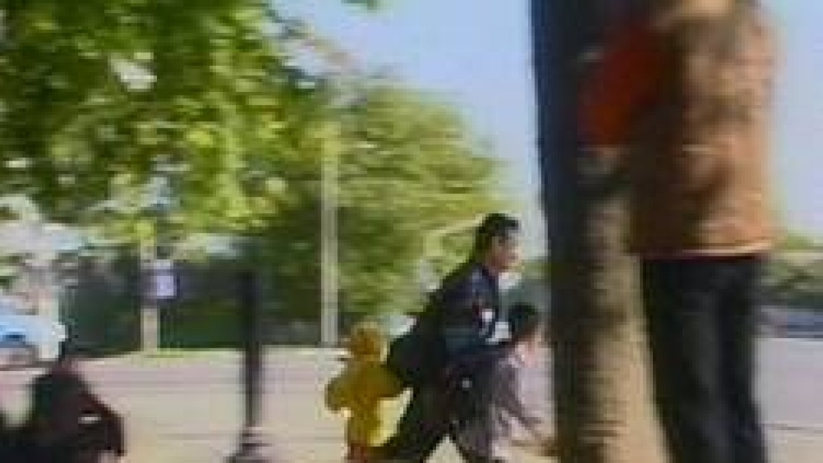 Un hombre y dos niños corren para intentar ponerse a cubierto en medio del intercambio de disparos