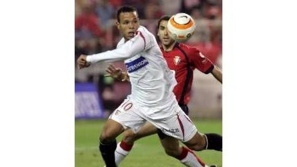 Luis Fabiano persigue el balón ante el acoso del defensa Patxi Puñal