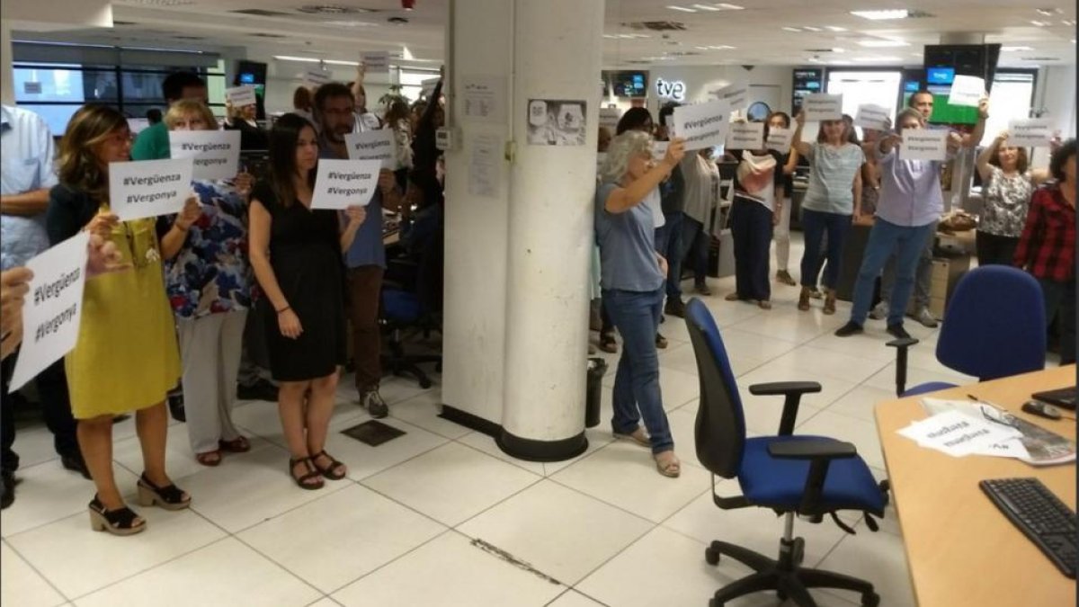 Imagen de la redacción de TVE con periodistas protestando por la cobertura del 1-O con carteles de vergüenza y "vergonya"