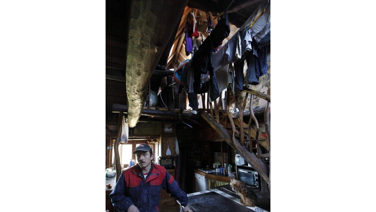 Israel Martínez, de 39 años, en la casa que salvó de la ruina para convertirla en un hogar donde vive con su mujer y sus tres hijos. En invierno, la cocina de leña seca la ropa y da calor a las habitaciones.