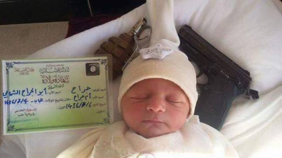 Fotografía de un bebé con un documento de identidad del Estado Islámico junto a una pistola y una granada.