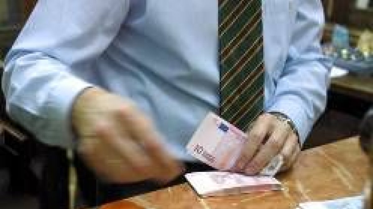 Un trabajador de un banco contando un fajo de billetes de diez euros