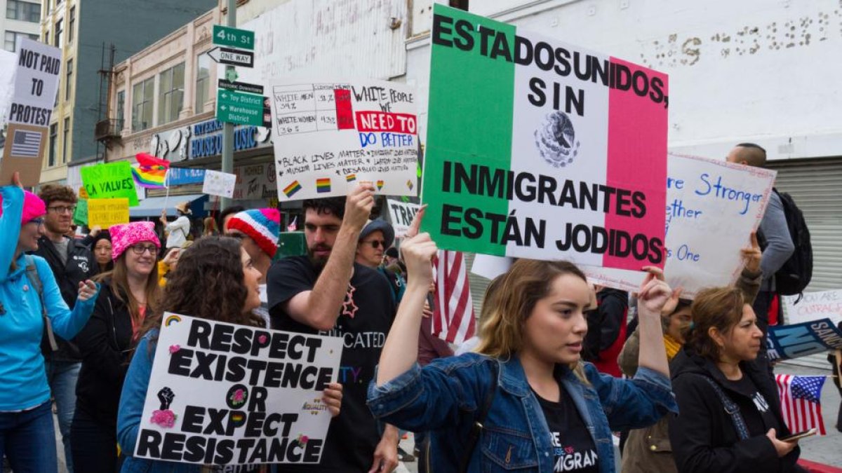 Manifestantes sostienen pancartas durante una protesta en Los Ángeles por el aumento de las redadas y las políticas antiinmigrantes.