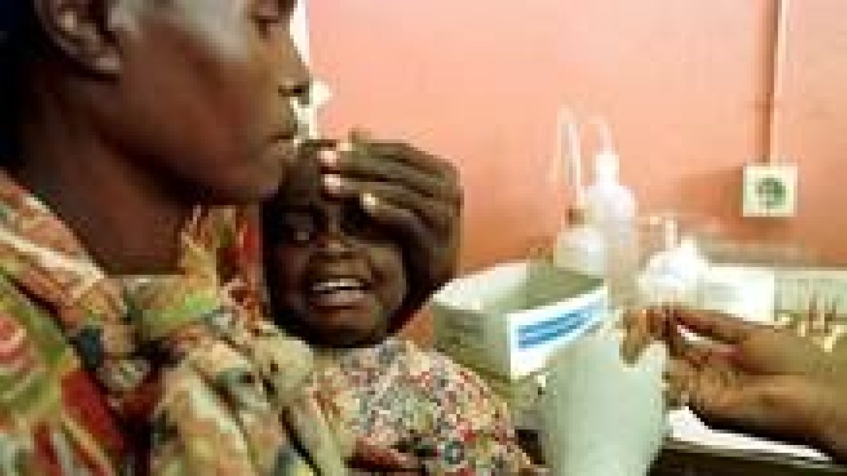 Un niño de Mozambique llora mientras le ponen una vacuna contra la malaria