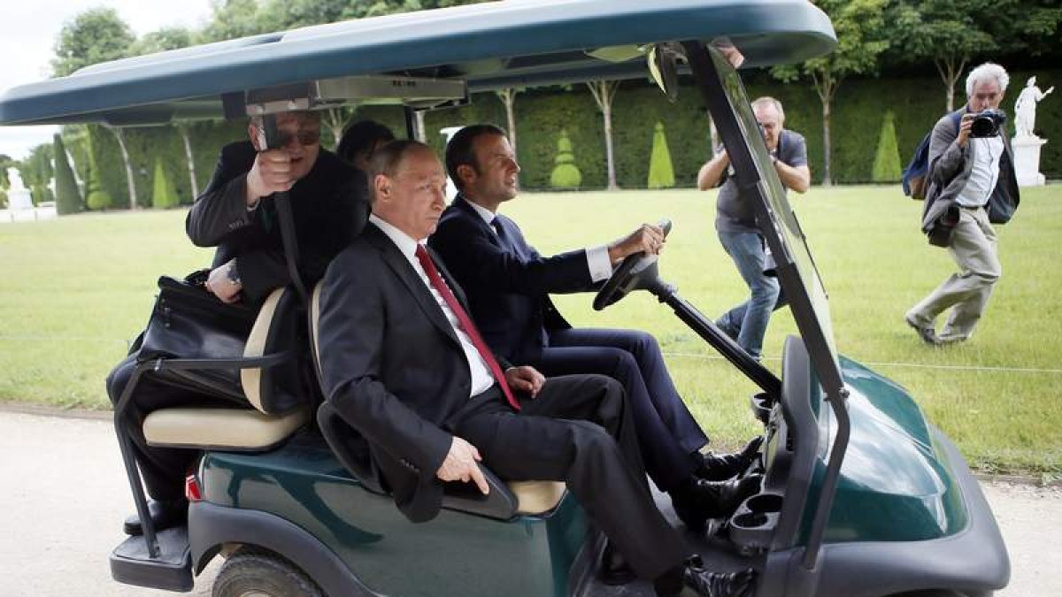 Macron conduce un carrito de golf en el Palacio de Versalles en compañía de Putin. FRANCOIS MORI