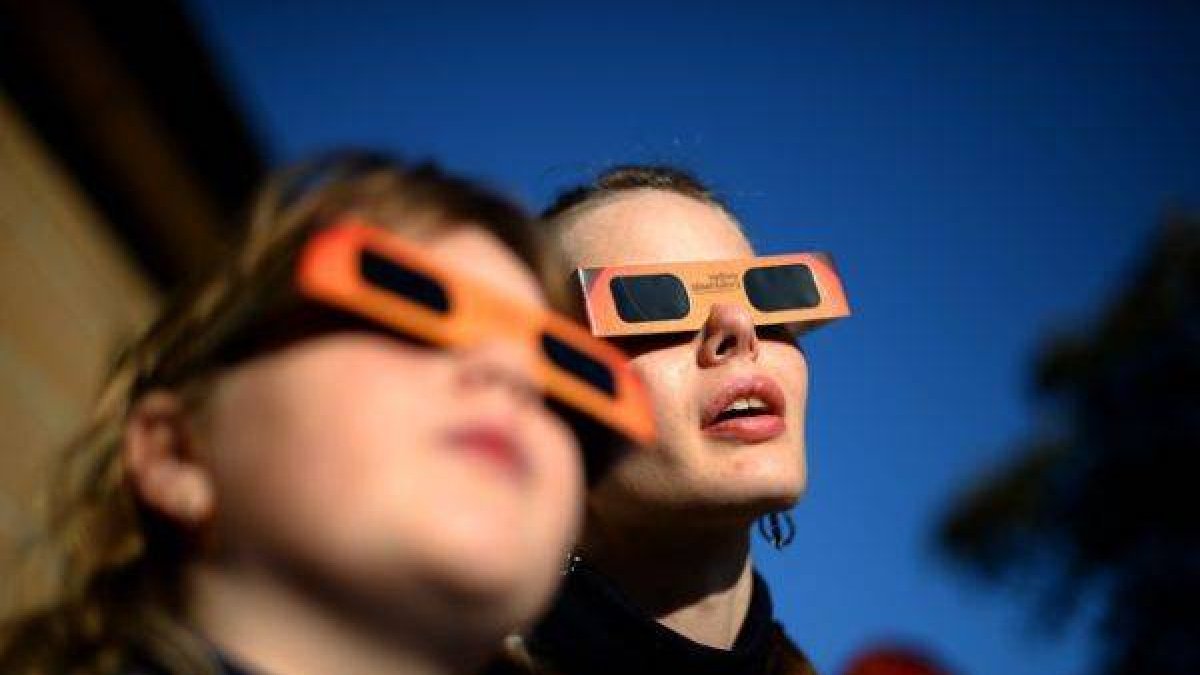 Una mujer y una niña contemplan un eclipse parcial de sol, en Sídney, en mayo del 2013.