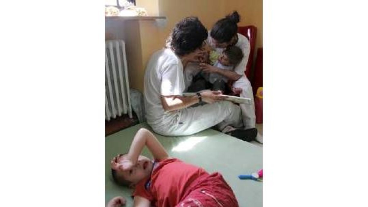 Dos cuidadoras atienden a niños con parálisis cerebral en Aspace