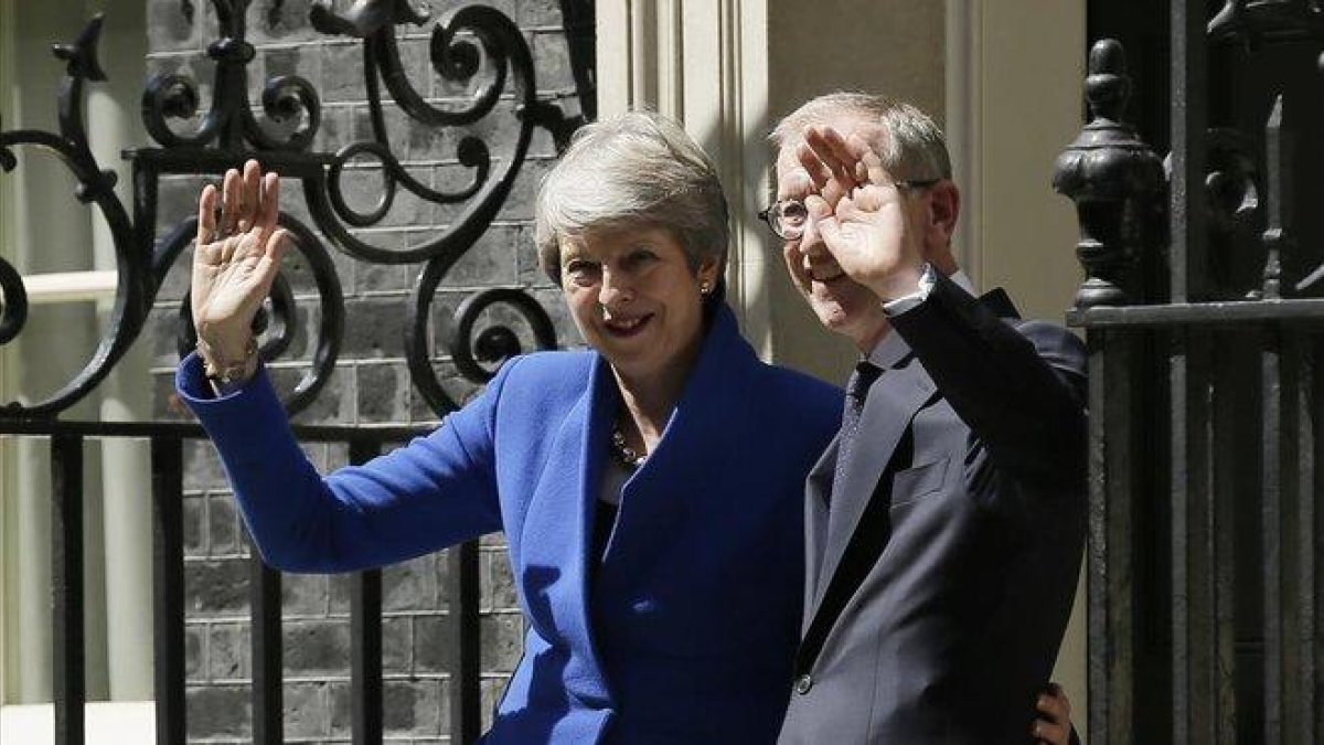 Theresa May junto a su marido Philip May saludan tras abandonar Downing Street.