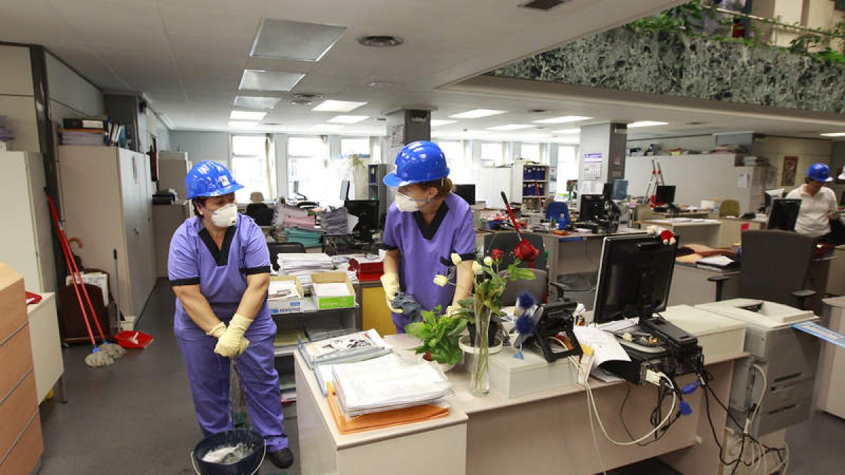 Trabajadoras de Emilsa limpiando el pasado lunes la planta baja del edificio principal de Ordoño.