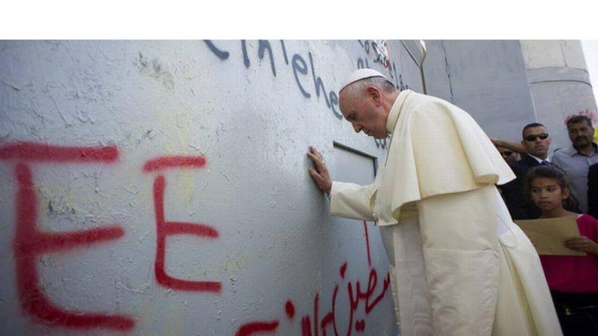 El Papa reza ante el muro que divide Israel y Palestina, en una parada imprevista en su recorrido por Belén, este domingo.